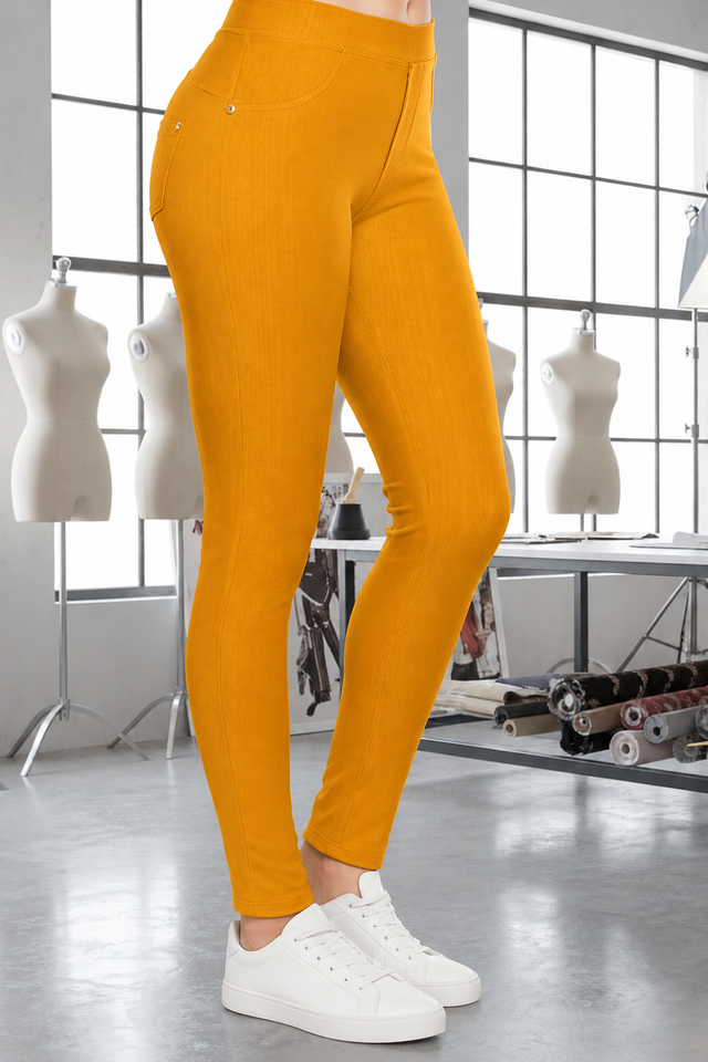Magic Pant Marigold detail in the signature atelier setting, with white sneakers.
