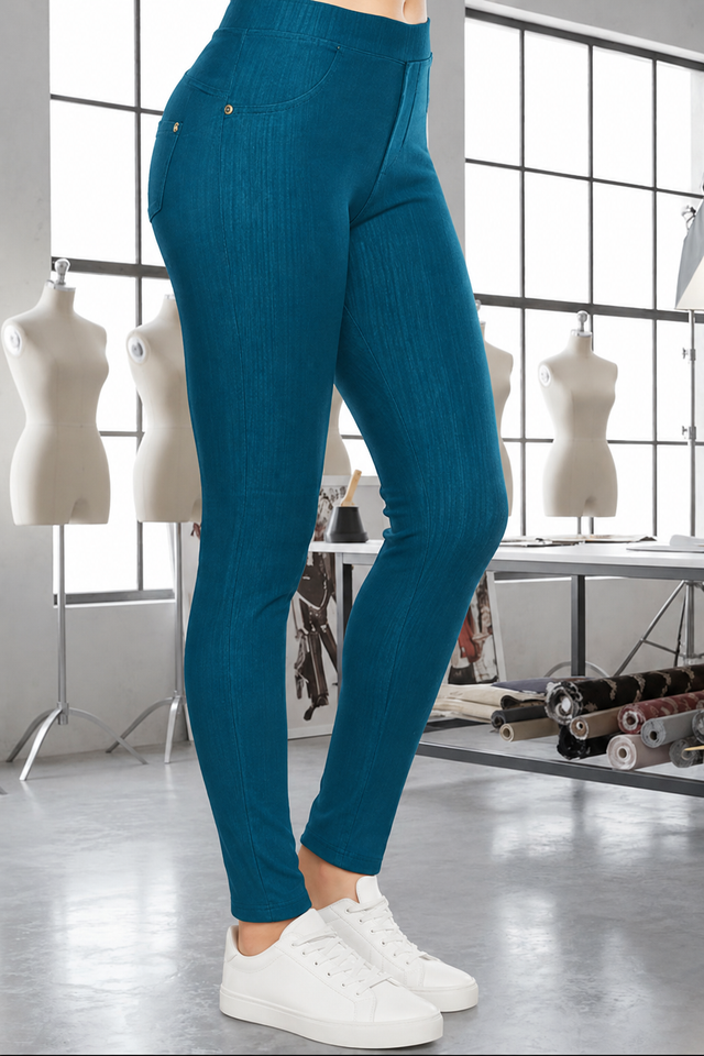 Magic Pant Peacock Teal detail in the signature atelier setting, with white sneakers.